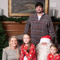 Family of four at the event taking a photo with Santa.